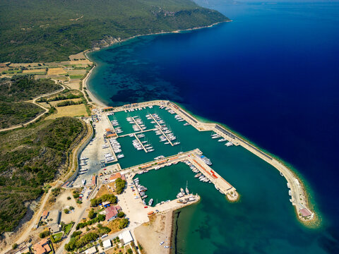 Aerial view of a marina filled with white yachts, nestled against the deep blue sea and verdant hills, a serene contrast of colors and textures, Datca, Mugla, T&Atilde;&frac14;rkiye.
