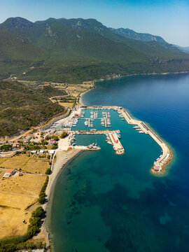 Aerial view of the Kormen Marina where turquoise waters meet the shore, nestled against a backdrop of verdant hills, Datca, Mugla, T&Atilde;&frac14;rkiye.