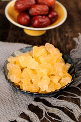 Exploring ancient handmade yellow rock sugar in a traditional setting with contrasting dried fruits