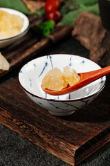 Crafted large grain yellow rock candy made from sugar cane displayed in a traditional bowl on a wooden surface