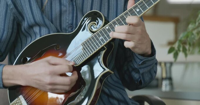 Male Musician Plays Mandolin. Caucasian Man Enjoys Playing Music 4K 10-bit