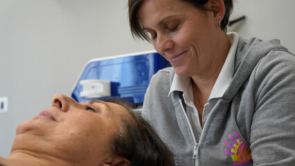 Physiotherapist performs neck massage on a woman for pain relief and relaxation