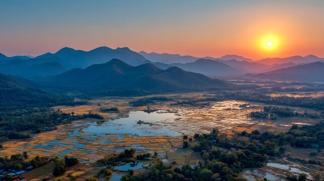 Lush valley landscape at sunset with mountains and paddy fields. - Powered by Adobe