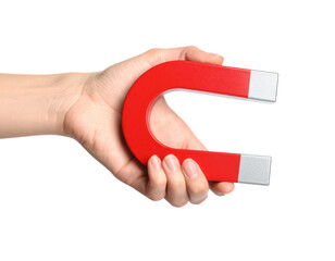 A hand holding a red horseshoe magnet with silver ends, representing magnetism and attraction.