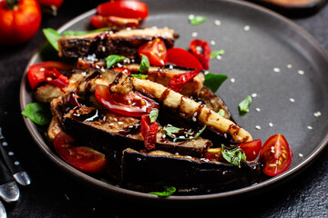 Appetizing salad of eggplants, tomatoes and basil in a black plate