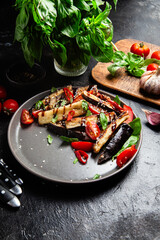 Appetizing salad of eggplants, tomatoes and basil in a black plate