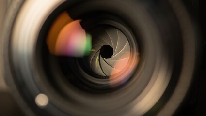 Close up of a camera lens aperture with colorful reflections on the glass