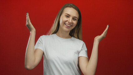 Woman smiling confidently against a vibrant red background, creating an energetic and cheerful...