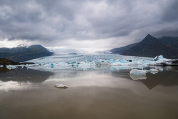 Fototapeta premium Dramatic Glacier Landscape with Icebergs Under Stormy Sky
