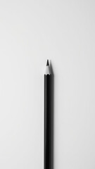 Sleek black pencil rests against clean white background, showcasing its sharp tip and elegant design
