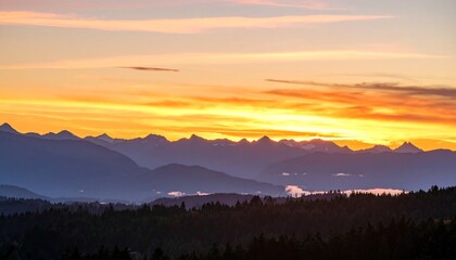 Vibrant sunset hues paint the sky above a distant mountain range, silhouetted against the warm light