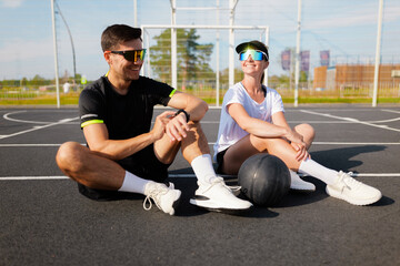 Friends enjoy a playful moment at a basketball court while relaxing