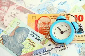 Nigerian naira currency money bills and alarm clock. The concept of time management and income