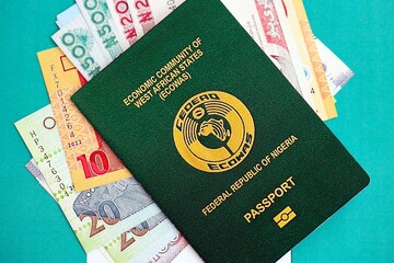 Nigerian naira currency money bills and passport lies on flag. The concept of travel and vacation