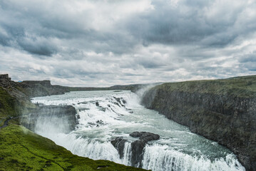 Waterfall Cascading Over Cliffside in Icelandic Landscape