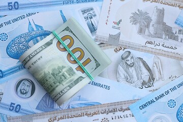 United Arab Emirates dirham currency money bills and bunch of us dollar banknotes. The concept of economics and currency exchange