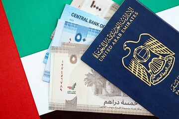 United Arab Emirates dirham currency money bills and passport lies on flag. The concept of travel...