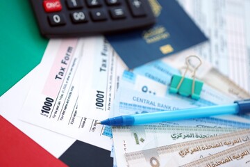 United Arab Emirates dirham money bills and calculator with tax form on flag. Taxation and...