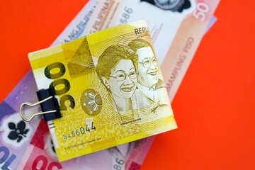 Philippines peso money bills in big amount on red. Finance and banking concept
