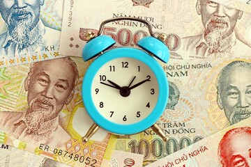 Vietnamese dong currency money bills and alarm clock. The concept of time management and income