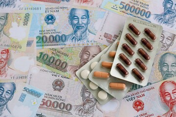Vietnamese dong currency money bills and medicine pills. The concept of medicine and pharmacy