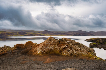 Scenic Rocky Shoreline at Lake Under Dramatic Clouds