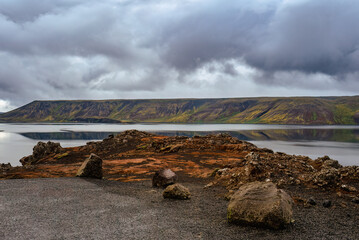 Scenic View of Lake and Mountains Under Dramatic Cloudy Sky

