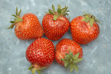 red strawberry berries, food backgroung, grey marble surface, tasty and delicious