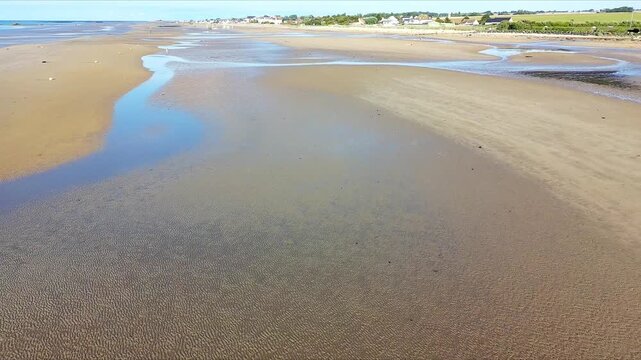 Scenic Drone Shot of Tidal Water Pools Forming on a Beach at Low Tide