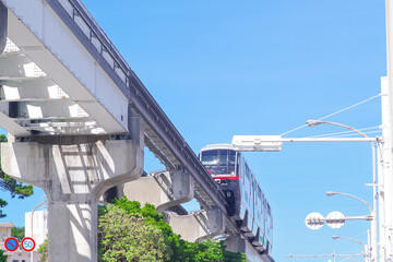 快晴の空を走る沖縄モノレール車両