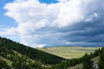 A large cloud finds a hilly valley