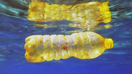 A vivid red plastic bottle drifts in the blue ocean, drawing attention to the growing issue of marine pollution and plastic waste in our waters.