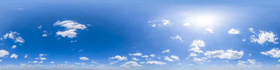 Spherical 360 degree panorama of blue sky, some cumulus clouds and sun shining 