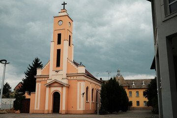Peach-colored church with clock tower built in 1901 in Sombor, Serbia. Historic Christian...