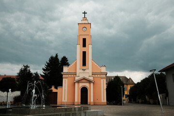 Peach-colored church with clock tower built in 1901 in Sombor, Serbia. Historic Christian...