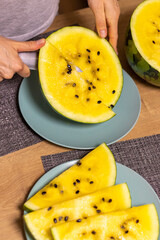 Person cuts watermelon with yellow flesh. Food