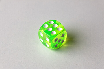 Close-up of a single genuine used green-colored semi-transparent dice