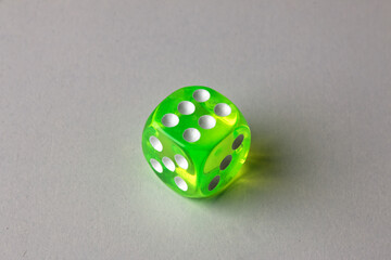 Close-up of a single genuine used green-colored semi-transparent dice
