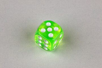Close-up of a single genuine used green-colored semi-transparent dice