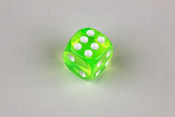 Close-up of a single genuine used green-colored semi-transparent dice