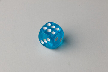 Close-up of a single genuine used blue-colored semi-transparent dice