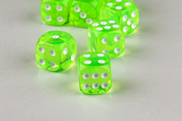 A random arrangement of green dice and a puzzle cup, captured after the dice have been cast.