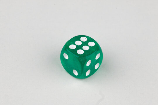 Close-up of a single genuine used green colored semi-transparent dice