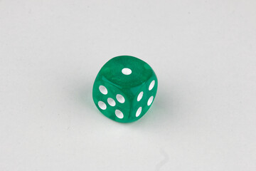 Close-up of a single genuine used green colored semi-transparent dice