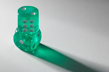 A random arrangement of green dice and a puzzle cup, captured after the dice have been cast.