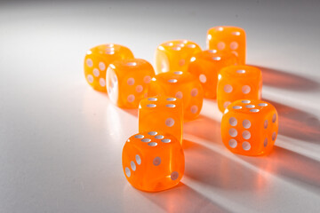 A random arrangement of orange dice and a puzzle cup, captured after the dice have been cast.