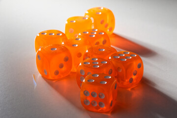 A random arrangement of orange dice and a puzzle cup, captured after the dice have been cast.