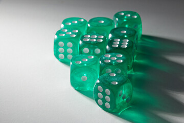 A random arrangement of green dice and a puzzle cup, captured after the dice have been cast.