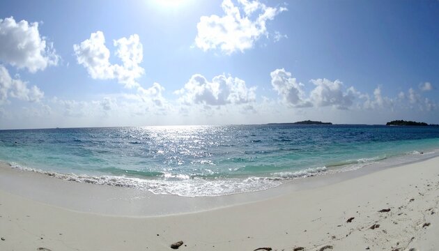 Beautiful sandy beach with white sand and rolling calm wave of turquoise ocean on Sun