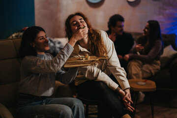Group of friends enjoying a casual evening indoors, with food, laughter, and conversation. The scene captures the warmth and joy of socializing in a relaxed and comfortable atmosphere.
